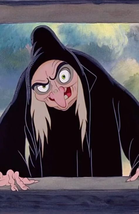 An animated witch with a mischievous grin and exaggerated features, wearing a black cloak and peering out from behind a window.